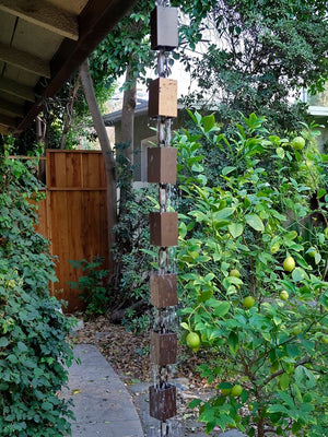 Square Kenchiku Aluminum Bronze Rain Chain on home with water running through multiple cups